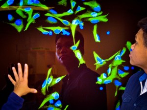 Tommy Nguyen in front of an image of nerve stem cells
