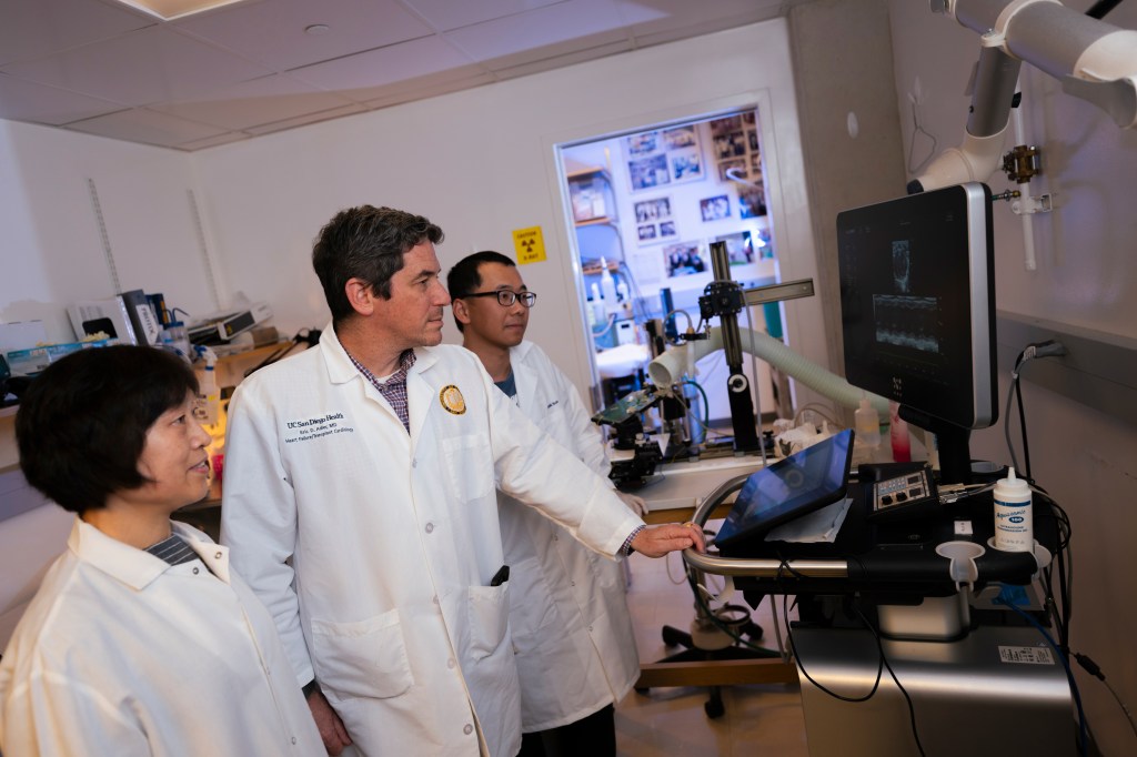 Eric Adler, MD with two of his reseachers looking at a monitor in the Adler Lab at UC San Diego.