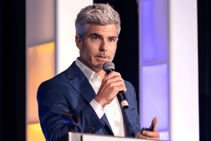 Jeffrey Randall Allen speaking with a microphone at the 2025 CIRM Trainee Networking Conference.